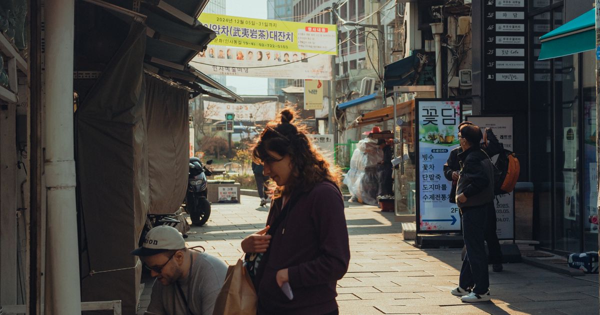 Shoppers walking along a market street in Seoul